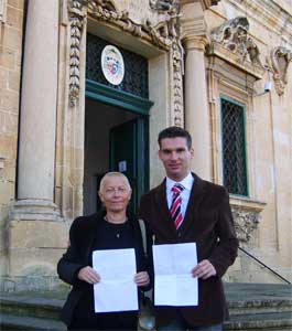 Dr. Ing. Patrick Attard and Lana Turner holding a photocopy of their Excommunication Declaration