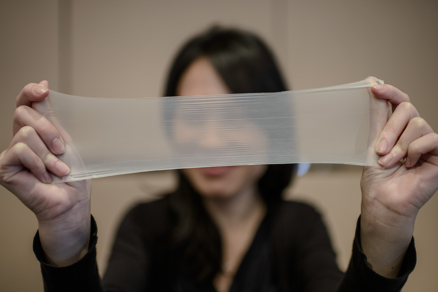 A woman streches a piece of latex from which the world's thinnest latex condoms are made during a press conference in Hong Kong on February 20, 2014. The condoms manufactured by the Chinese company Guangzhou Daming United Rubber Products Limited are 0.036mm thin on average and listed on the Guinness Records book as the "thinnest latex condom". AFP PHOTO / Philippe Lopez (Photo credit should read PHILIPPE LOPEZ/AFP/Getty Images)