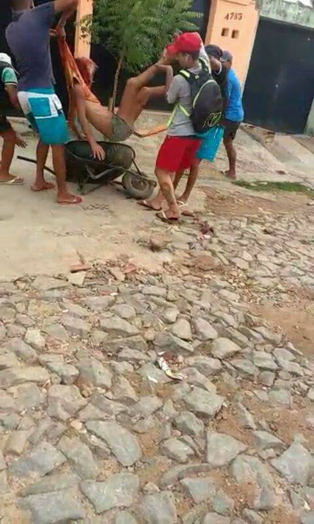 Dandara dos Santos being put into a wheel barrow