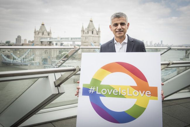 Mayor of London Sadiq Khan holding a rainbow roundel