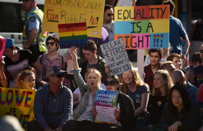 Supporters of same sex marriage carry banners and shout slogans as they gather on a street in Sydney on August 6, 2017.  Australia's Liberal Party, the senior partner in the ruling coalition, is set to debate its same-sex marriage policy on August 7 amid tensions between conservative and moderate elements over whether to dump a policy of holding a plebiscite on the issue in favour of other options, despite strong popular support for marriage equality. / AFP PHOTO / PETER PARKS        (Photo credit should read PETER PARKS/AFP/Getty Images)