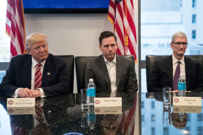 NEW YORK, NY - DECEMBER 14: (L to R) President-elect Donald Trump, Peter Thiel and Tim Cook, chief executive officer of Apple, Inc., listen during a meeting with technology executives at Trump Tower, December 14, 2016 in New York City. This is the first major meeting between President-elect Trump and technology industry leaders. (Photo by Drew Angerer/Getty Images)