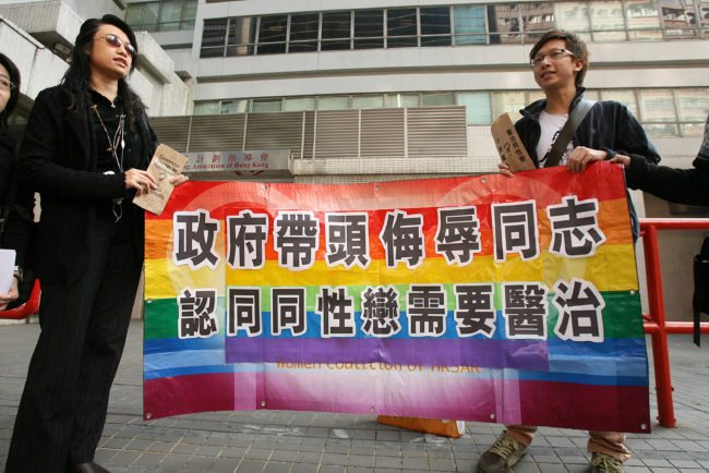 Hong Kong, CHINA:  A gay and homosexual group lead a protest to government offices in Hong Kong 01 December 2006.  The group were urging the government to end discrimination to homosexuals with regard to an organisation which promotes conversion therapy for homosexuals. Banner reads" Government leads campaign to insult gays and believes they need a cure"    AFP PHOTO/MIKE CLARKE  (Photo credit should read MIKE CLARKE/AFP/Getty Images)