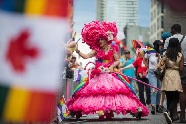 A drag queen high five's spectators during the Pride Parade in Toronto, Ontario, June 25, 2017. The event draws hundreds of thousands of spectators every year. / AFP PHOTO / GEOFF ROBINS (Photo credit should read GEOFF ROBINS/AFP/Getty Images)