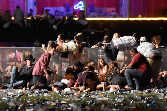 LAS VEGAS, NV - OCTOBER 01: People scramble for shelter at the Route 91 Harvest country music festival after apparent gun fire was heard on October 1, 2017 in Las Vegas, Nevada. A gunman has opened fire on a music festival in Las Vegas, leaving at least 20 people dead and more than 100 injured. Police have confirmed that one suspect has been shot. The investigation is ongoing. (Photo by David Becker/Getty Images)