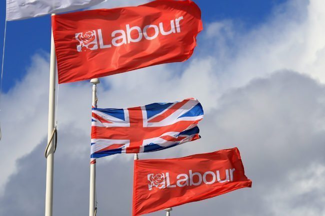 LIVERPOOL, ENGLAND - SEPTEMBER 25: The Union flag flies between Labour party flags during the Labour party conference at the ACC on September 25, 2016 in Liverpool, England. Party leader Jeremy Corbyn is rallying members hoping to re-unite the party after being re-elected leader yesterday. (Photo by Christopher Furlong/Getty Images)
