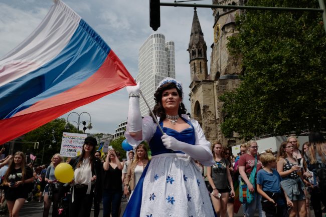 A participant from Russia waves a Russian flag during Berlin's annual Christopher Street Day (CSD) gay pride parade on July 22, 2017. Gays and lesbians all around the World are celebrating the Christopher Street Day (CSD) gay and lesbian pride parade. / AFP PHOTO / John MACDOUGALL        (Photo credit should read JOHN MACDOUGALL/AFP/Getty Images)