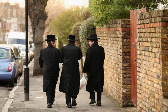 LONDON, ENGLAND - JANUARY 19: Jewish men walk along the street in the Stamford Hill area of north London on January 19, 2011 in London, England. The residents of Stamford Hill are predominately Hasidic Jewish and only New York has a larger community of Hasidic Jews outside Israel. The area contains approximately 50 synagogues and many shops cater specifically for the needs of Orthodox Jews.   (Photo by Oli Scarff/Getty Images)