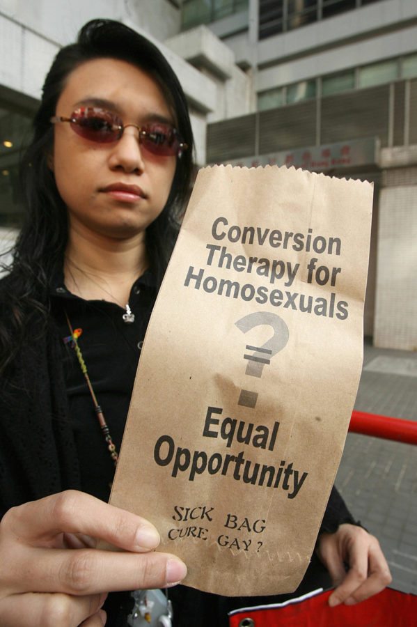 Hong Kong, CHINA: A gay and homosexual group lead a protest to government offices in Hong Kong 01 December 2006. The group were urging the government to end discrimination to homosexuals with regard to an organisation which promotes conversion therapy for homosexuals. Banner reads" Government leads campaign to insult gays and believes they need a cure" AFP PHOTO/MIKE CLARKE (Photo credit should read MIKE CLARKE/AFP/Getty Images)