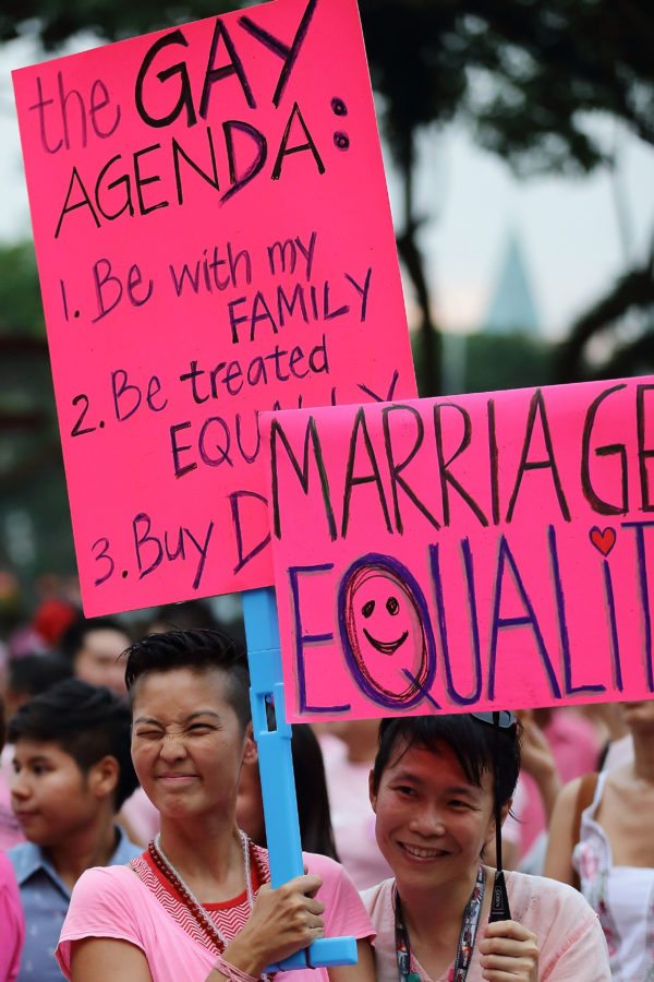 SINGAPORE - JUNE 30: Participants hold up placards during the 'Night Pink Dot' event arrange to increase awareness and understanding of the lesbian, gay, bisexual and transgender community in Singapore at Hong Lim Park on June 30, 2012 in Singapore. The event is the fourth annual gathering held in support of the freedom to love. (Photo by Suhaimi Abdullah/Getty Images)