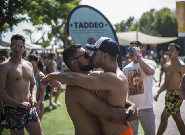 SHEFAYIM, ISRAEL - JUNE 02:  Two men kiss as people dance during a Water Park party on June 2, 2016 in Shefayim, Israel. Ahead of the annual Gay pride parade in Tel Aviv taking place on June 3, LGBT tourists from across the world visit Israel for the week in a build-up to Tel Aviv Pride, one of the Pride capitols of the world.  (Photo by Ilia Yefimovich/Getty Images)