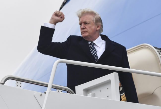 TOPSHOT - US President Donald Trump gestures as he boards Airforce One at Joint Base Andrews, Maryland on January 12, 2018, for a weekend trip to Mar-a-Lago. / AFP PHOTO / Nicholas Kamm (Photo credit should read NICHOLAS KAMM/AFP/Getty Images)
