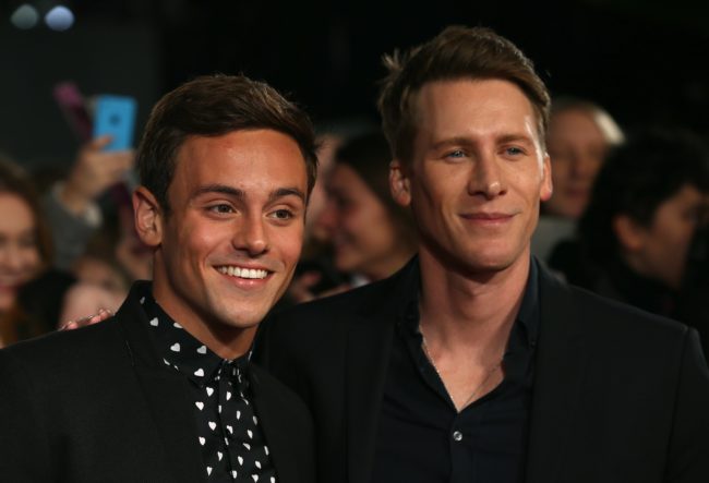 Brtish Olympic athlete Tom Daley (L) and his partner American screenwriter Dustin Lance Black arrive to attend the UK Premiere of the film "The Hunger Games: Mockingjay Part 2" in central London on November 5, 2015.   AFP PHOTO / JUSTIN TALLIS        (Photo credit should read JUSTIN TALLIS/AFP/Getty Images)