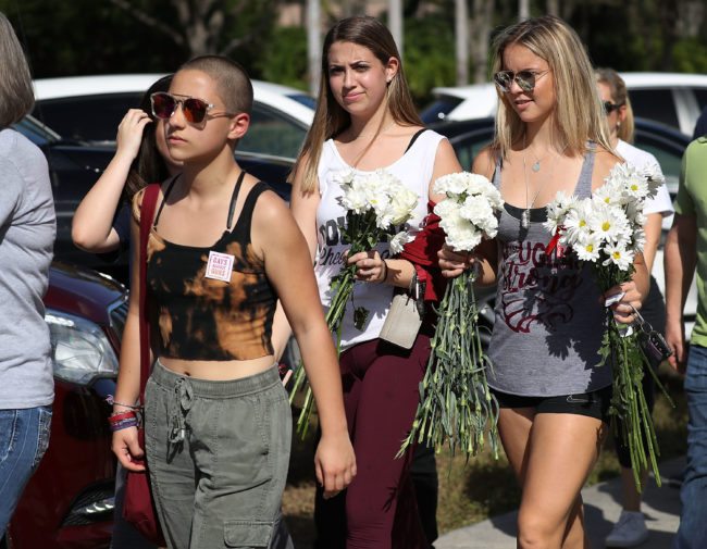 PARKLAND, FL - FEBRUARY 25: Emma Gonzalez (L), a senior at Marjory Stoneman Douglas High School, and others walk to campus on February 25, 2018 in Parkland, Florida. Today, students and parents were allowed on campus for the first time since the shooting that killed 17 people on February 14. Police arrested 19-year-old former student Nikolas Cruz for the 17 murders. (Photo by Joe Raedle/Getty Images)
