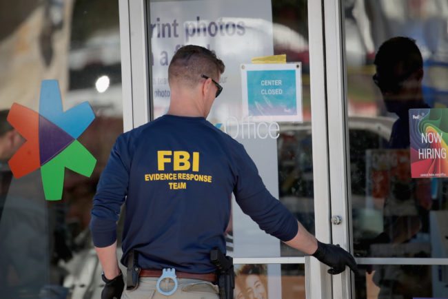SUNSET VALLEY, TX - MARCH 20:  FBI agents collect evidence at a FedEx Office facility following an explosion at a nearby sorting center on March 20, 2018 in Sunset Valley, Texas. A package, reported to have been shipped from this store, exploded while being transported on a conveyor shortly after midnight this morning at the sorting facility in Schertz, Texas causing minor injuries to one person. The explosion is believed to be related to several recent package bombs that have been detonated in Austin, Texas.  (Photo by Scott Olson/Getty Images)