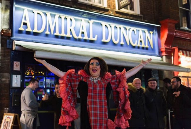 Men and drag queen standing outside the Admiral Duncan London gay bar