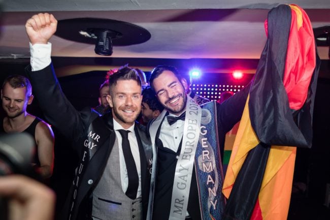 German Enrique Doleschy (R) reacts after he won the Mister Gay Europe 2018 beauty contest as Matt Rood from UK - Mister Gay Europe 2017 stands by in the Haven And Hell club in Poznan, August 11, 2018. (Photo by Wojtek RADWANSKI / AFP)        (Photo credit should read WOJTEK RADWANSKI/AFP/Getty Images)