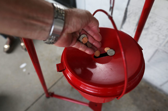 A donation is made into a Salvation Army red kettle