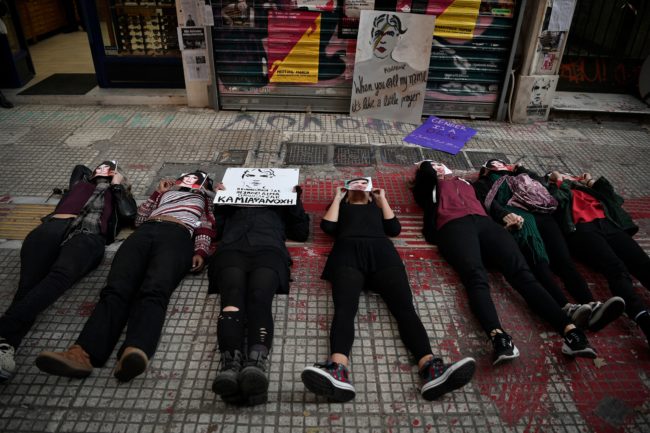 Activists lie down at the spot where gay activist Zak Kostopoulos was killed two month ago during a rally in Athens on November 24, 2018.