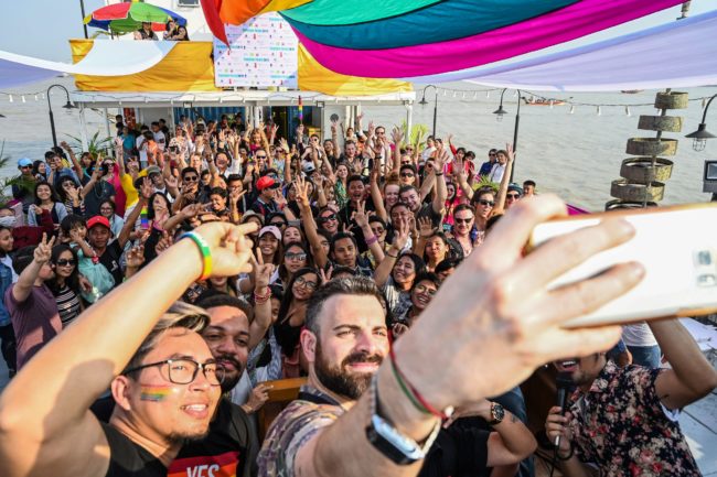 Members of the lesbian, gay, bisexual, and transgender (LGBT) community dance and take selfies under rainbow flags displayed on a boat during the Pride Boat Parade, an event of the Myanmar's Yangon Pride festival in Yangon on January 26, 2019.