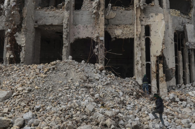 ISIS news: An Iraqi climbs up the rubble of the destroyed seven-storey Chadirji Building, designed by celebrated Iraqi architect Rifat Chadirji in the 1960s, on January 13, 2019, in the city of Mosul.