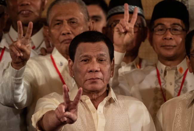 Philippine President Rodrigo Duterte (C) gives a peace sign with members of Moro Islamic Liberation Front (MILF) during the Ceremonial Confirmation of the Bangsamoro Organic Law Plebescite Law Canvass Results and Oath-taking of Transition Authority at the Malacanang palace in Manila on February 22, 2019.