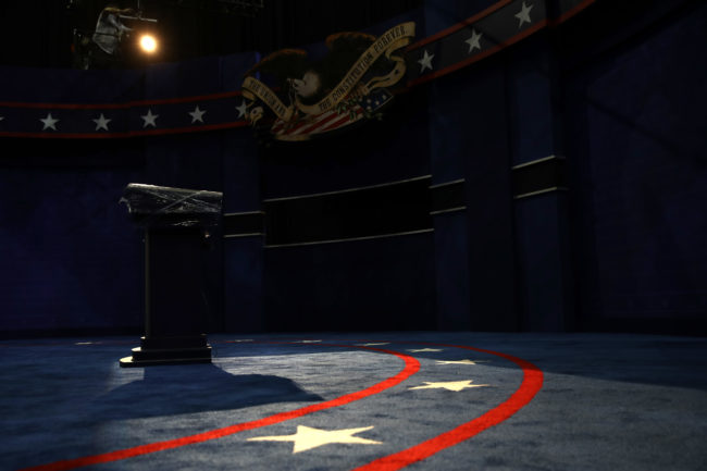 Lighting technicians adjust lighting on the lecterns to be used by Democratic presidential candidate Hillary Clinton and Republican presidential candidate Donald Trump on the set of the final presidential debate at the Thomas & Mack Center October 17, 2016 in Las Vegas, Nevada.