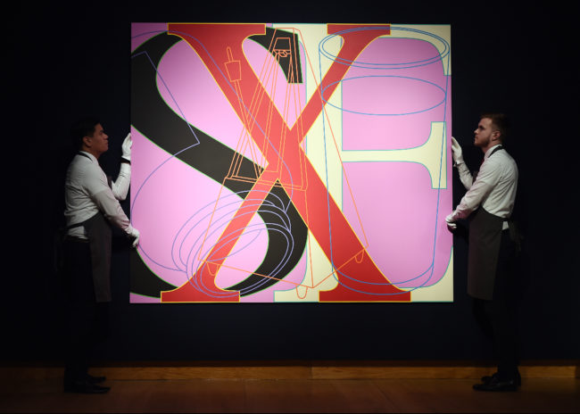 Staff members poses with work by Michael Craig-Martin as Christie's presents an exhibition of works from it's George Michael Collection Highlights at Christie's on March 08, 2019 in London, England.
