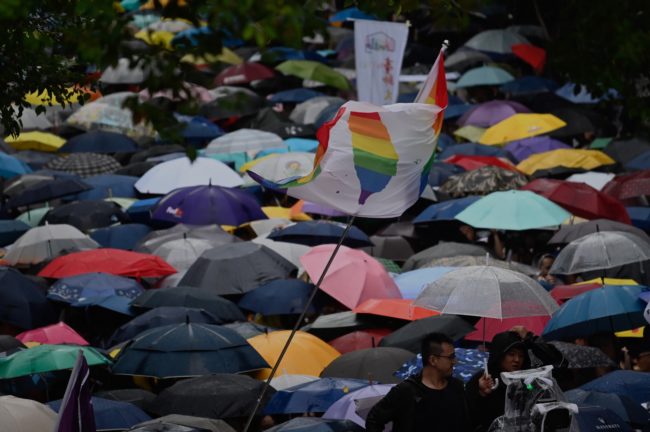 Gay rights supporters wait for the results under the rain outside Parliament while law makers discusses the same sex marriage bill in Taipei on May 17, 2019. 