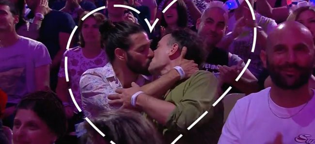 Same-sex couple kisses for the camera during Dana International's performance at Eurovision. 