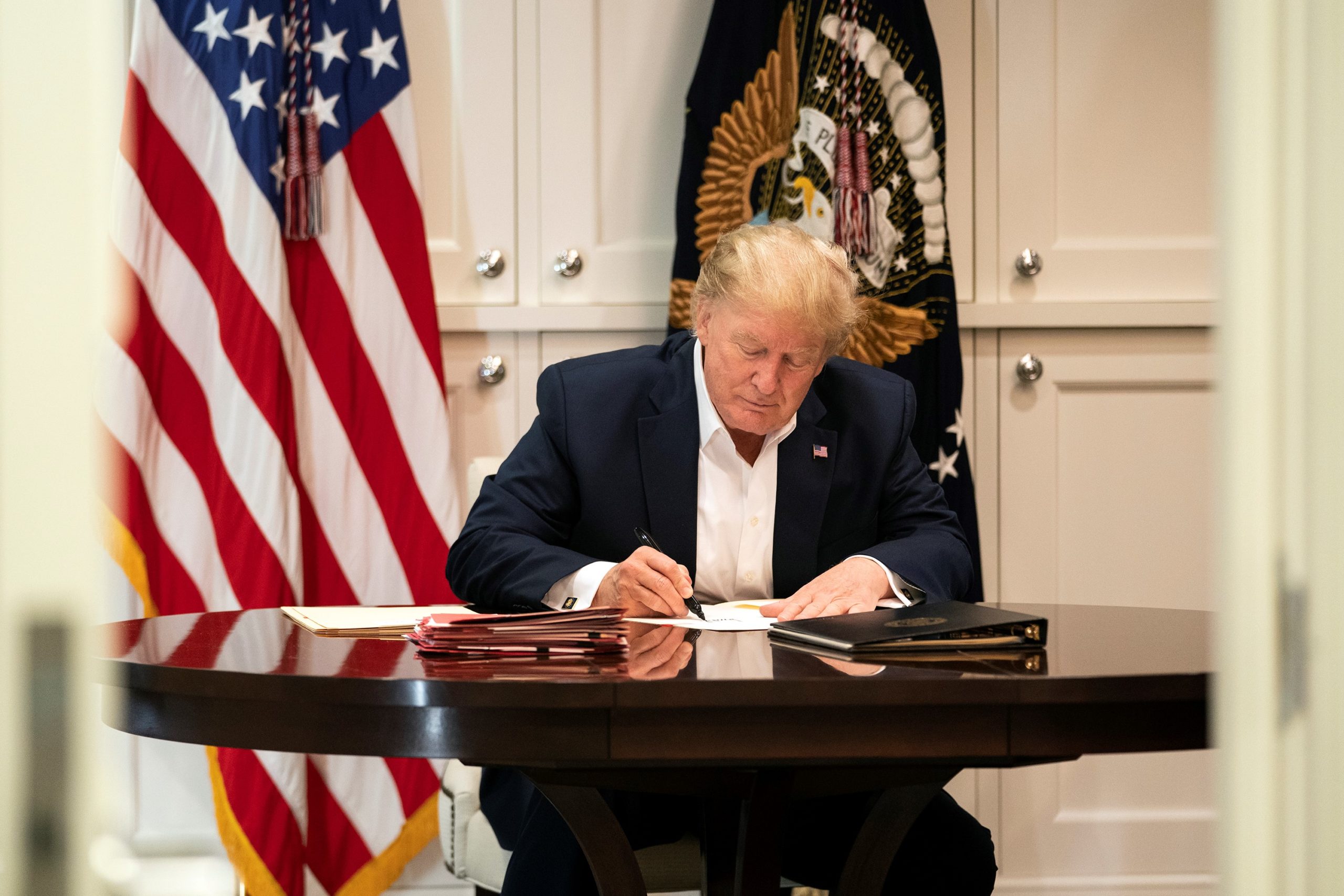 Donald Trump, uncle of Mary Trump, signs a blank piece of paper inside the Presidential Suite at Walter Reed National Military Medical Center, in a photos the White House claimed featured the President at work